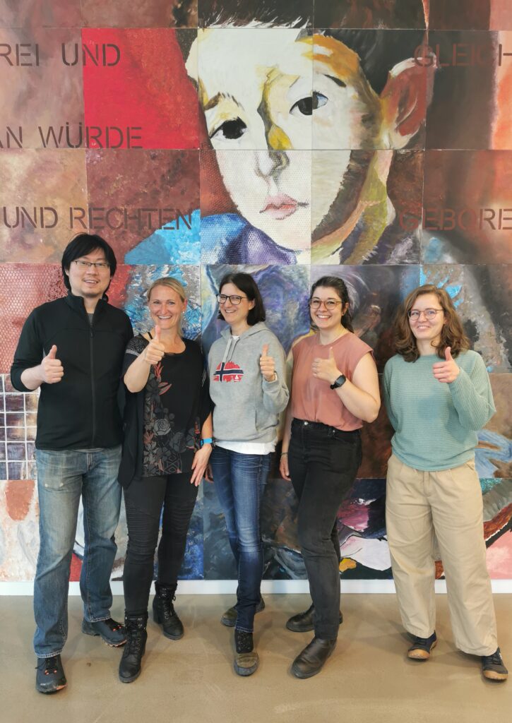 Researcher team poses with thumb outstretched