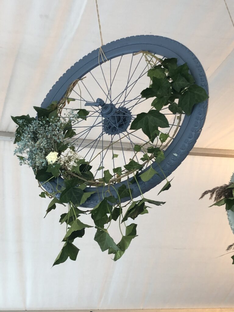 Deco: wheel of a bicycle hangs from the ceiling decorated with leaves